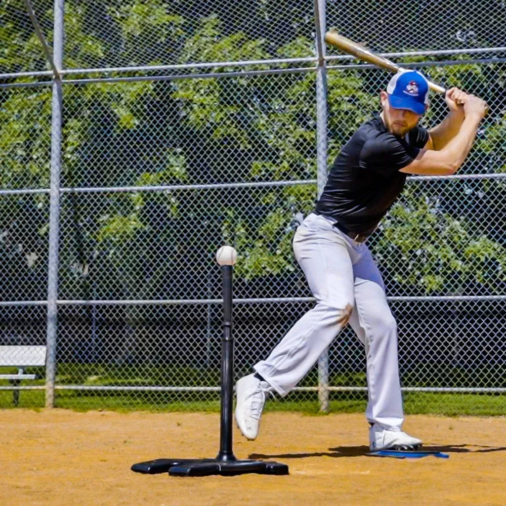 A man is swinging a baseball bat at a ball on a baseball field.