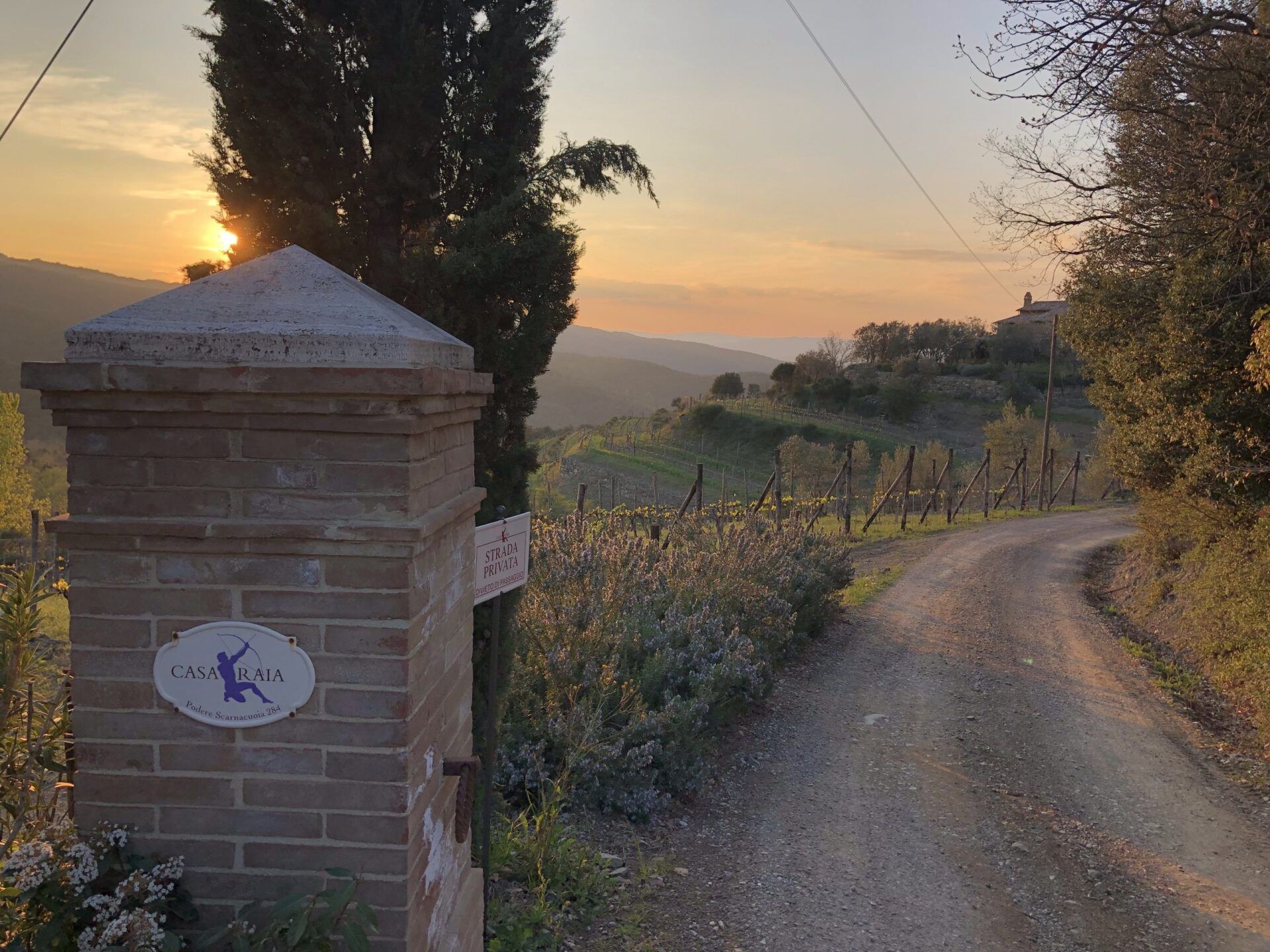 Brick gate with sign, and a dirt road that leads to Casa Raia.