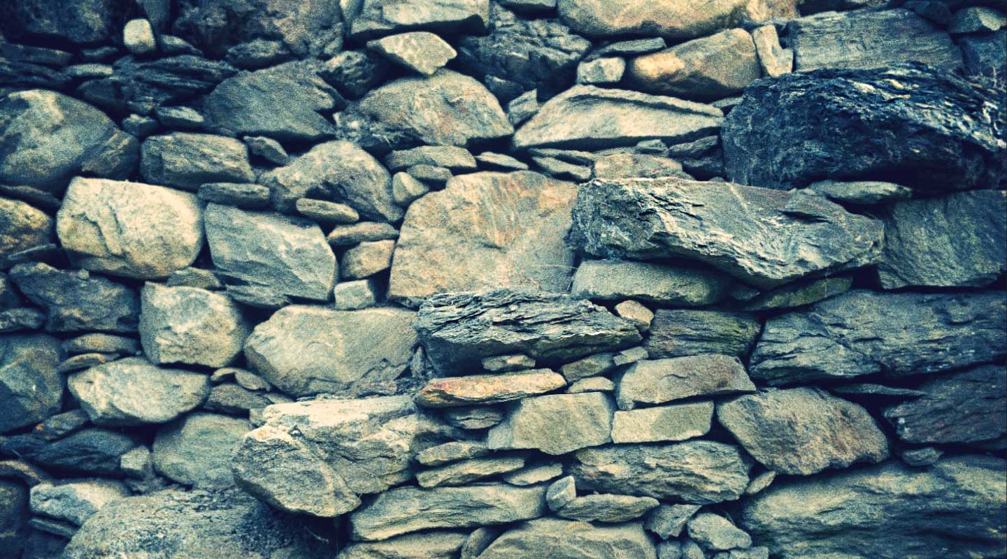 Rough stone wall, various sizes and shades of gray and tan.