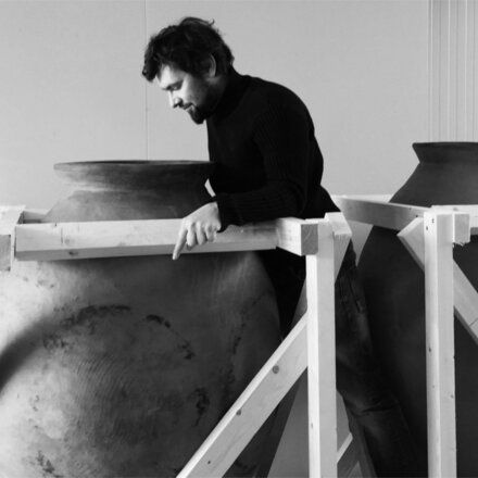 A winemaker at Zillinger inspects large clay fermentation vessels inside the winery.