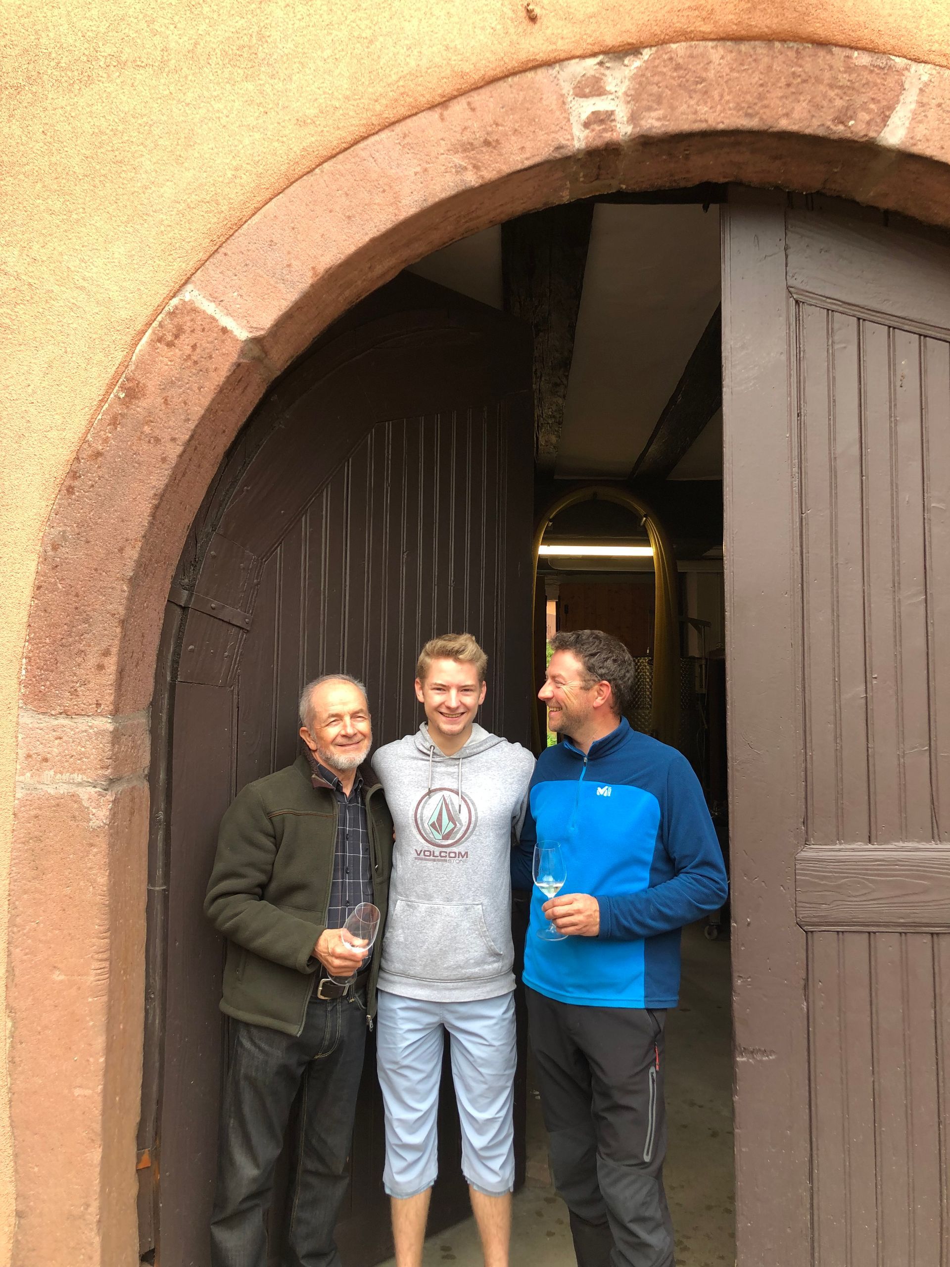 Albert Boxler with family members from different generations standing at the doors of Domaine Albert Boxler.