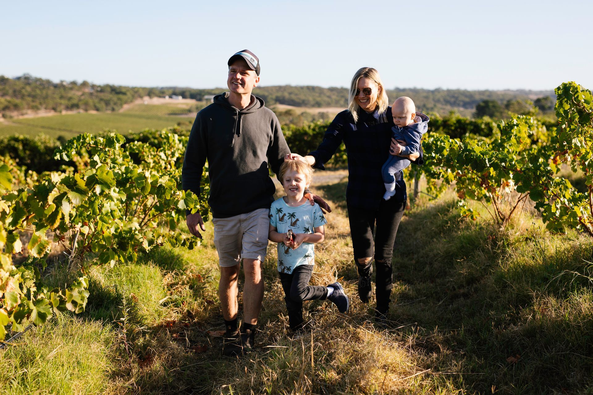 Bondar family walking through a vineyard.