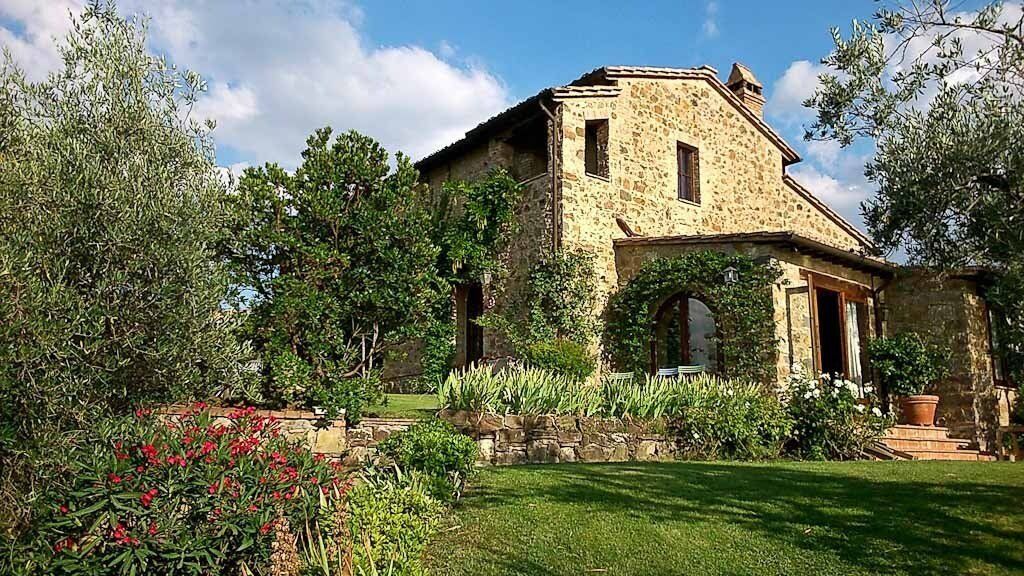 Casa Raia stone building with a green lawn and plants.