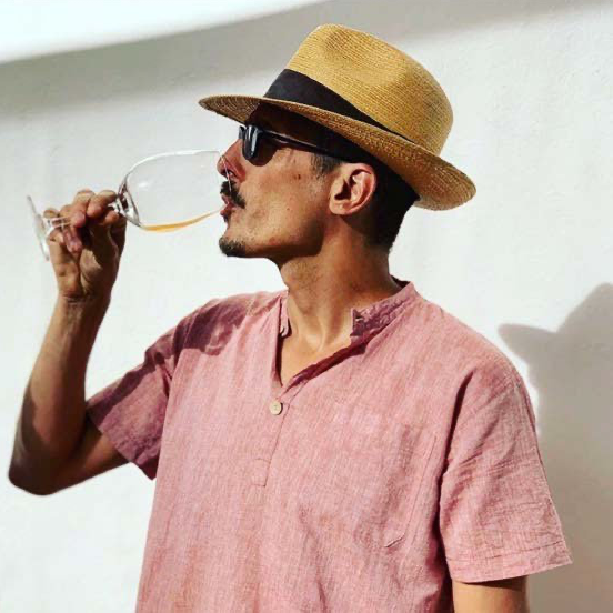 Casa Raia worker drinking wine outdoors.