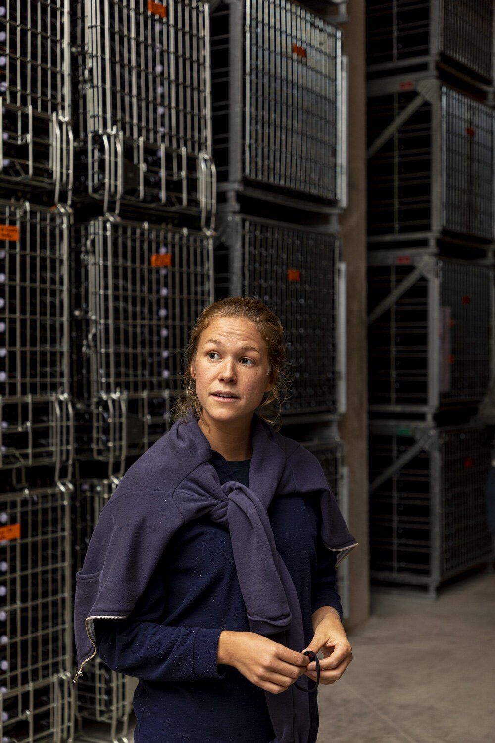 Winemaker of Champagne Lelarge-Pugeot standing near stacks of metal storage containers.