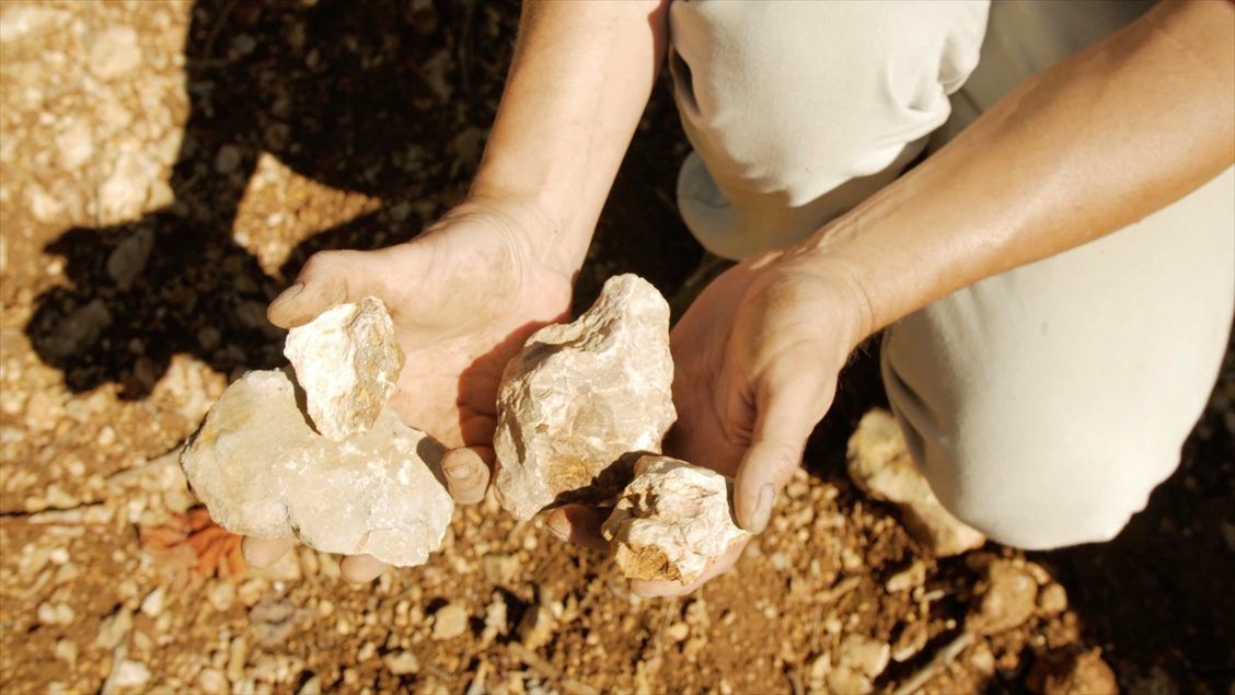 Person holding light-colored rocks at Gilbert & Gaillard