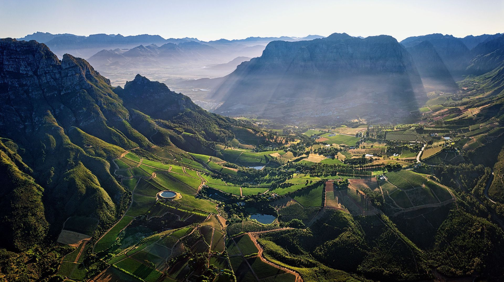 Panoramic view of vineyards set within a mountain valley