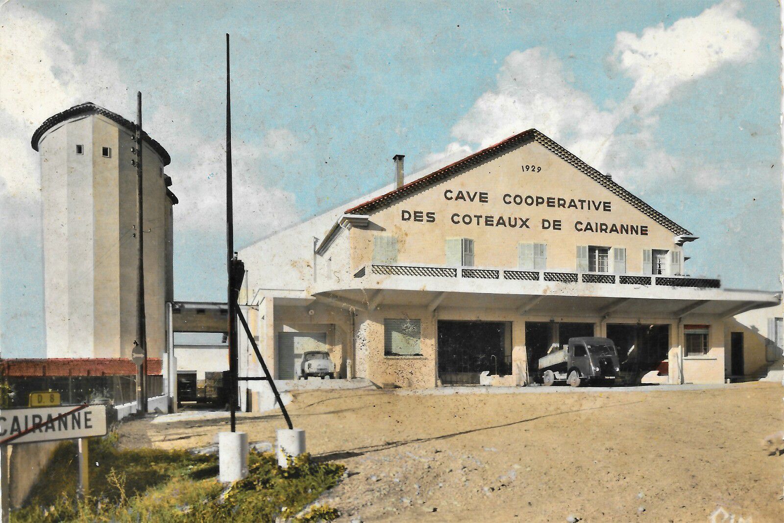 Cave de Cairanne building with yellow façade, white roof and a silo.
