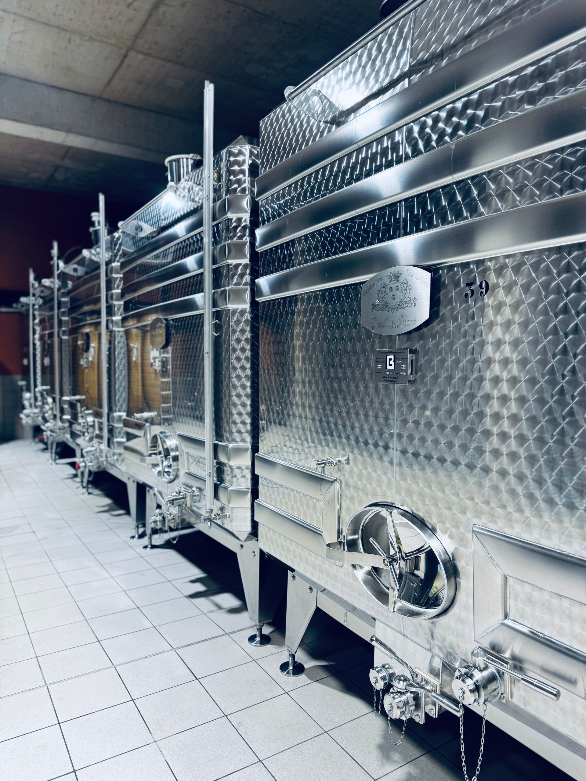 Stainless steel wine fermentation tanks in a winery.