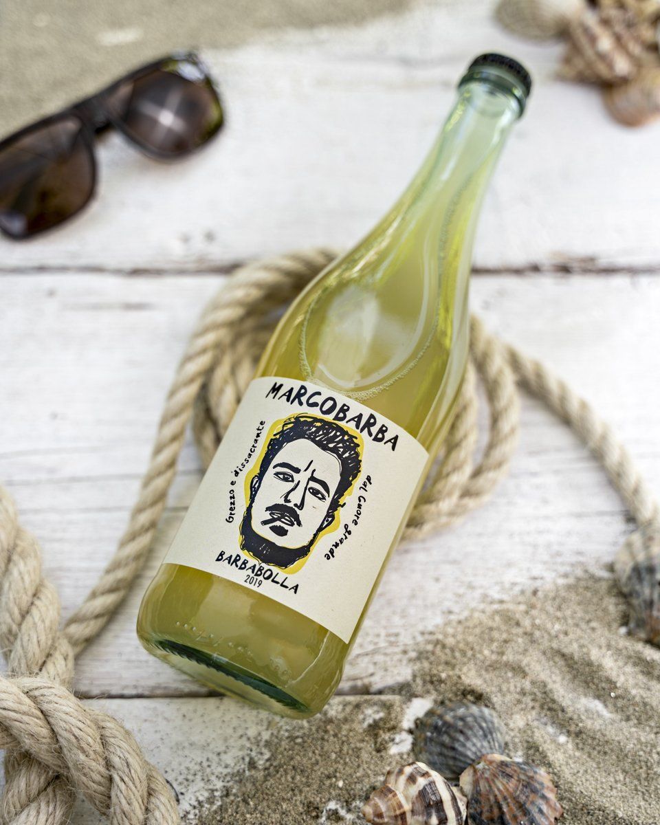 Bottle of Marcobarba Barbabolla wine on a rustic surface with rope and seashells