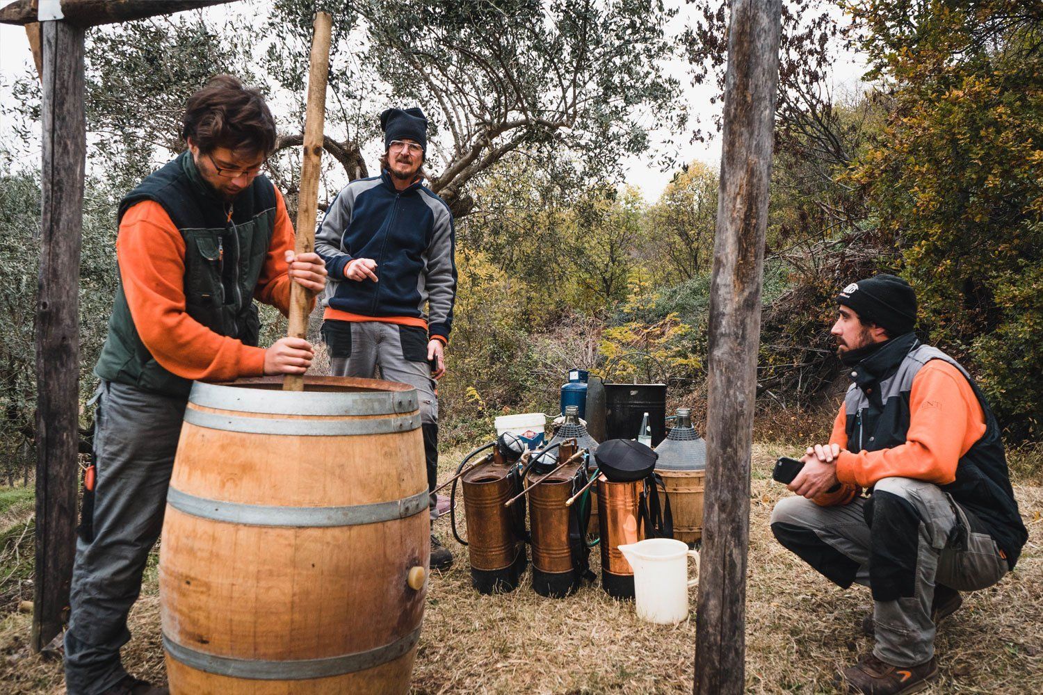Marcobarba winemakers stirring wine outdoors.