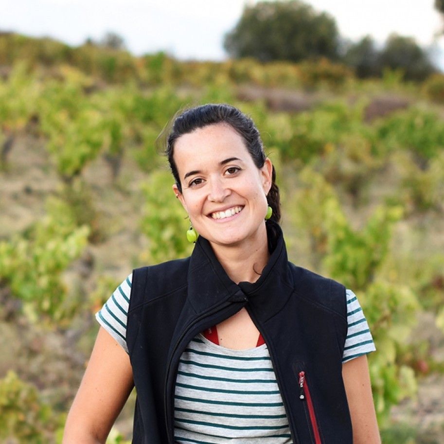 Sandra Bravo smiling, with a background full of vineyards
