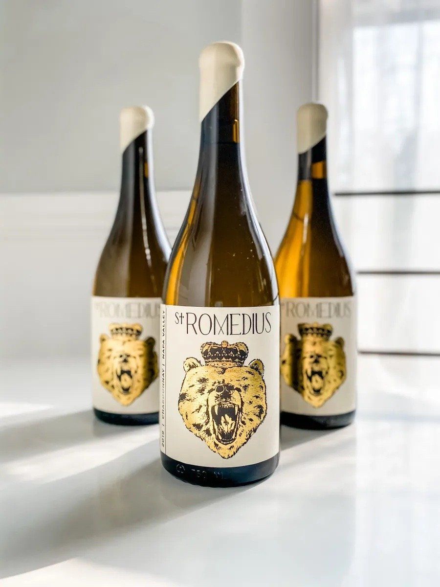St. Romedius Chardonnay bottle with illustrated bear label, two bottles in the background