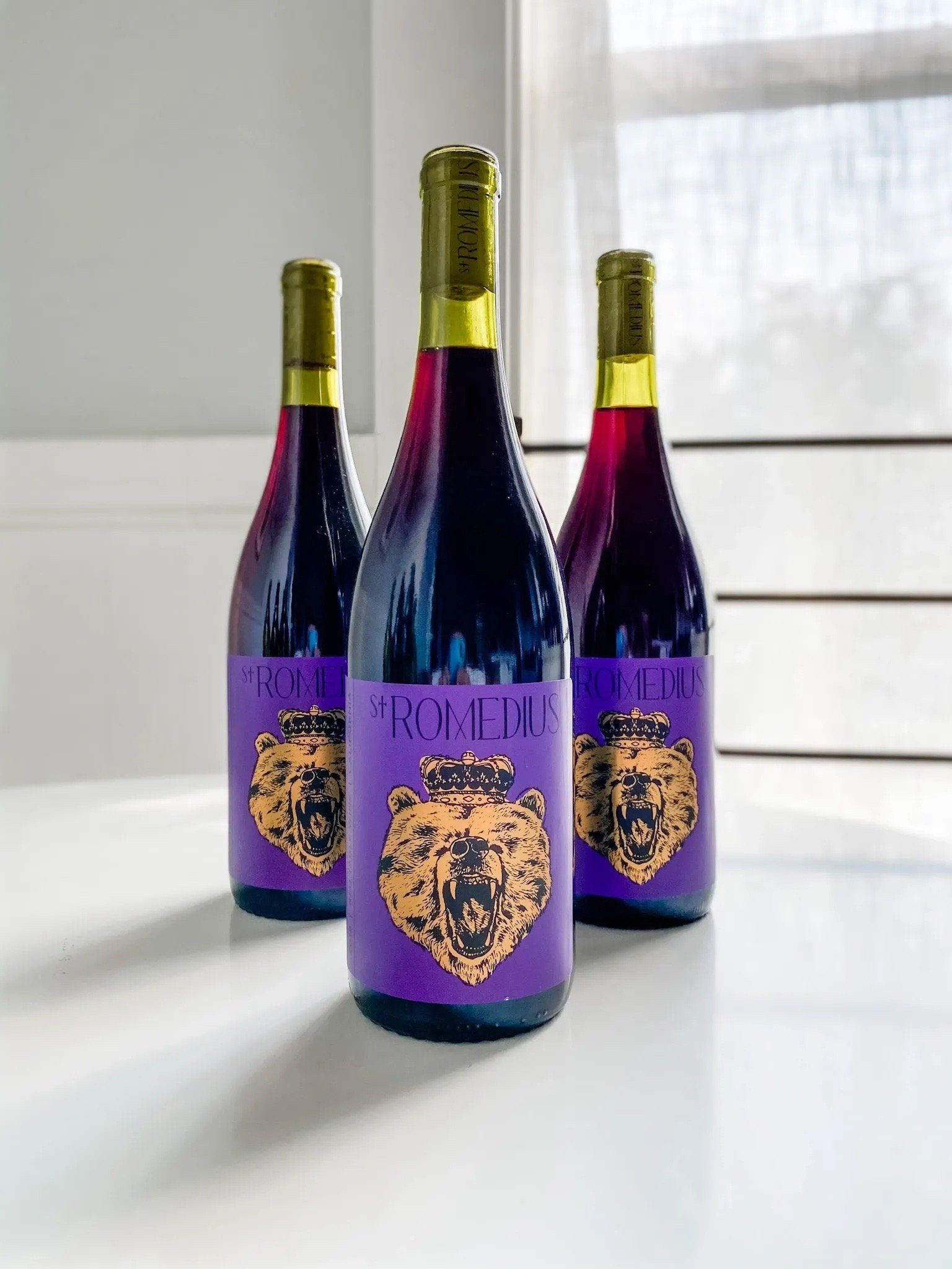 St. Romedius red table wine bottle with bear label, two bottles in the background.