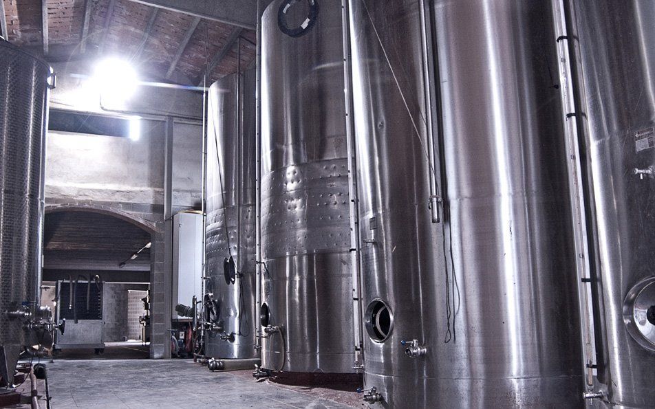 Suriol - metal wine fermentation tanks in a cellar.