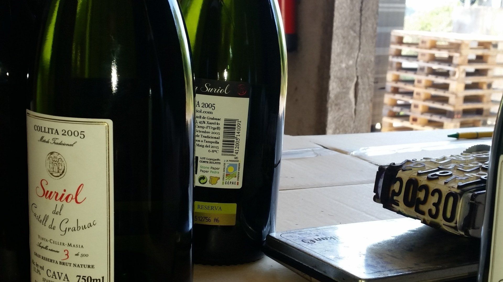 Suriol sparkling wine bottles during the labeling process.