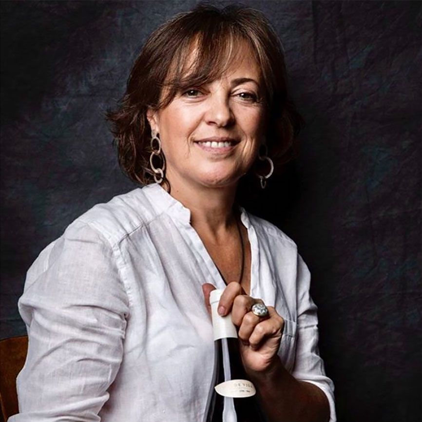 Carmen López, winemaker at Uva de Vida, holding a bottle of wine.
