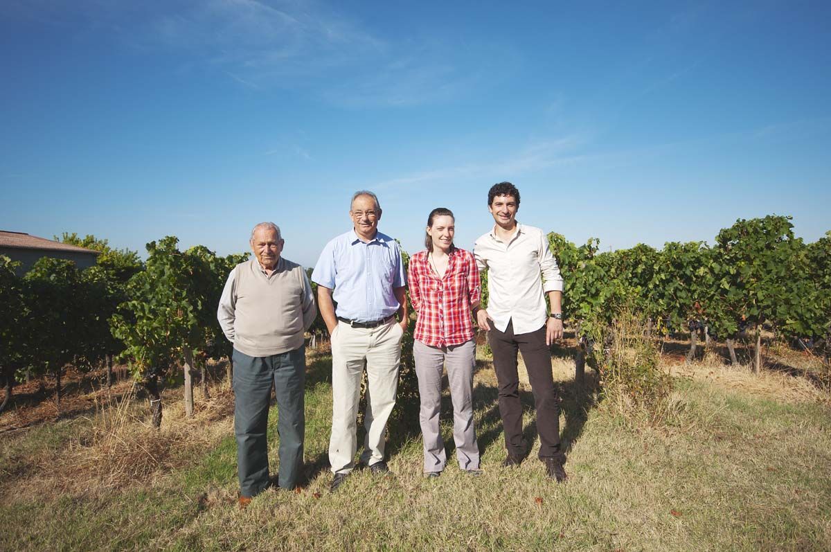 Members of the Château Haut Grelot team standing together in the vineyard.