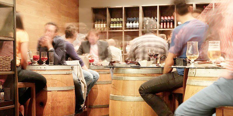 People drinking wine in a wine bar or tasting room People drinking wine in a wine bar or tasting room