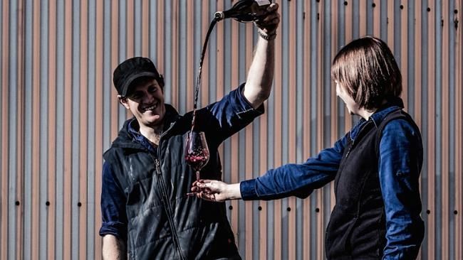 Two Unico Zelo winemakers pour wine into a glass during a tasting.