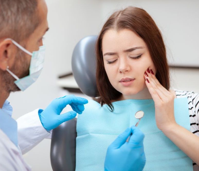 woman in pain at dentist | root canals in garland tx 75040