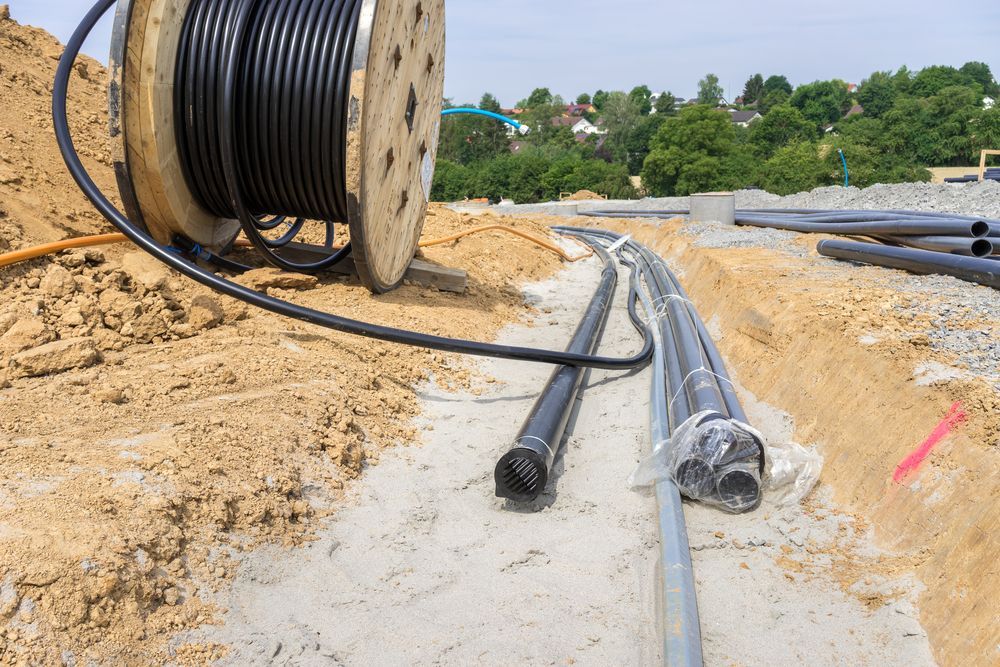 Large Spool of Black Cable and Several Black Pipes — East Point Earthmoving in Byron Bay, NSW