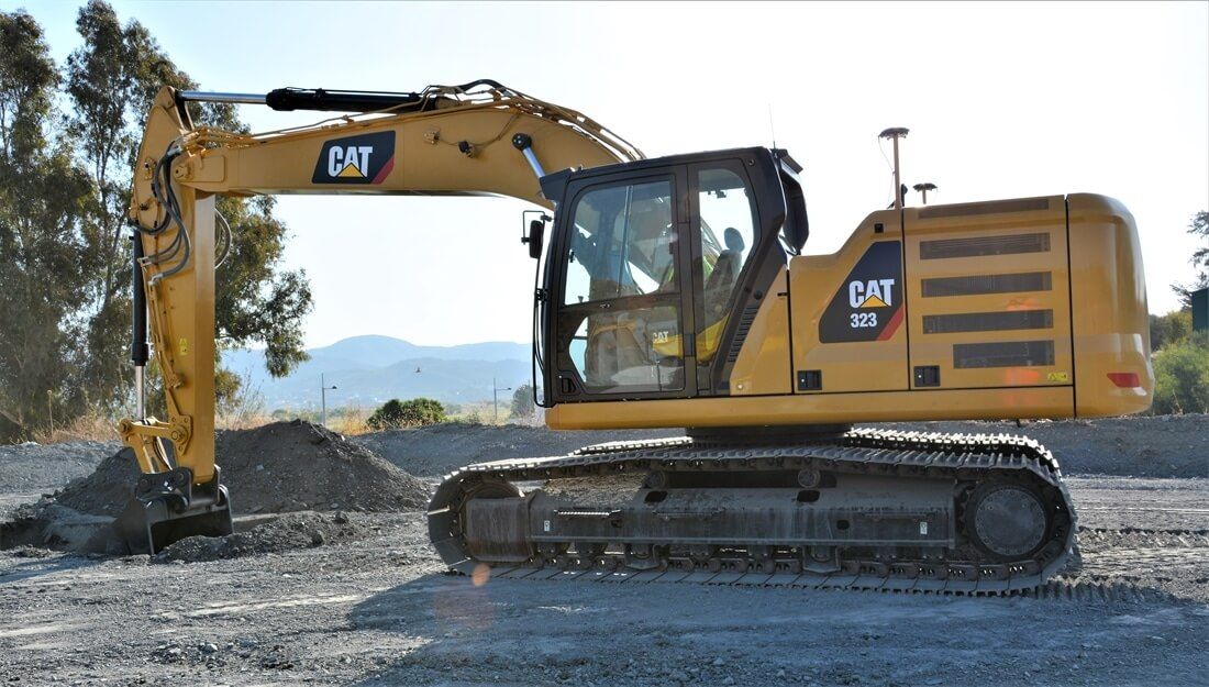 A Yellow Cat Excavator Is Parked In A Gravel Area — East Point Earthmoving in Bangalow, NSW