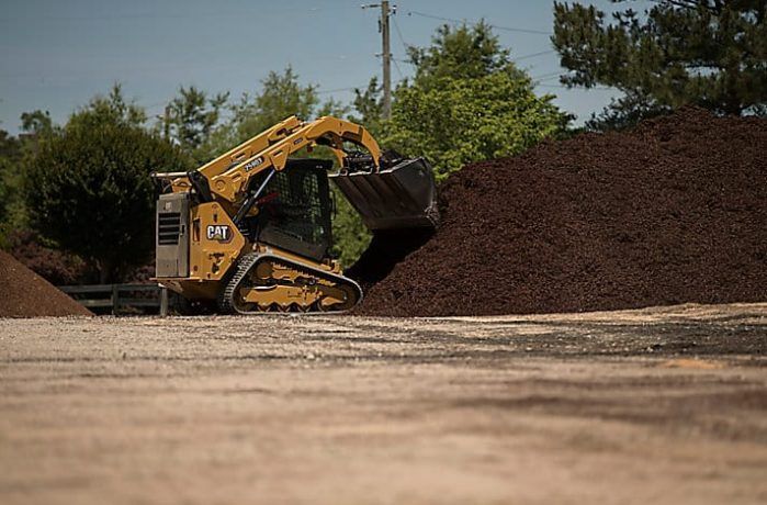 A Bulldozer Is Loading Mulch Into A Pile Of Mulch — East Point Earthmoving in Byron Bay, NSW
