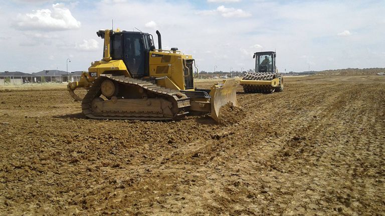 Two Bulldozers Are Working In A Dirt Field — East Point Earthmoving in Byron Bay, NSW