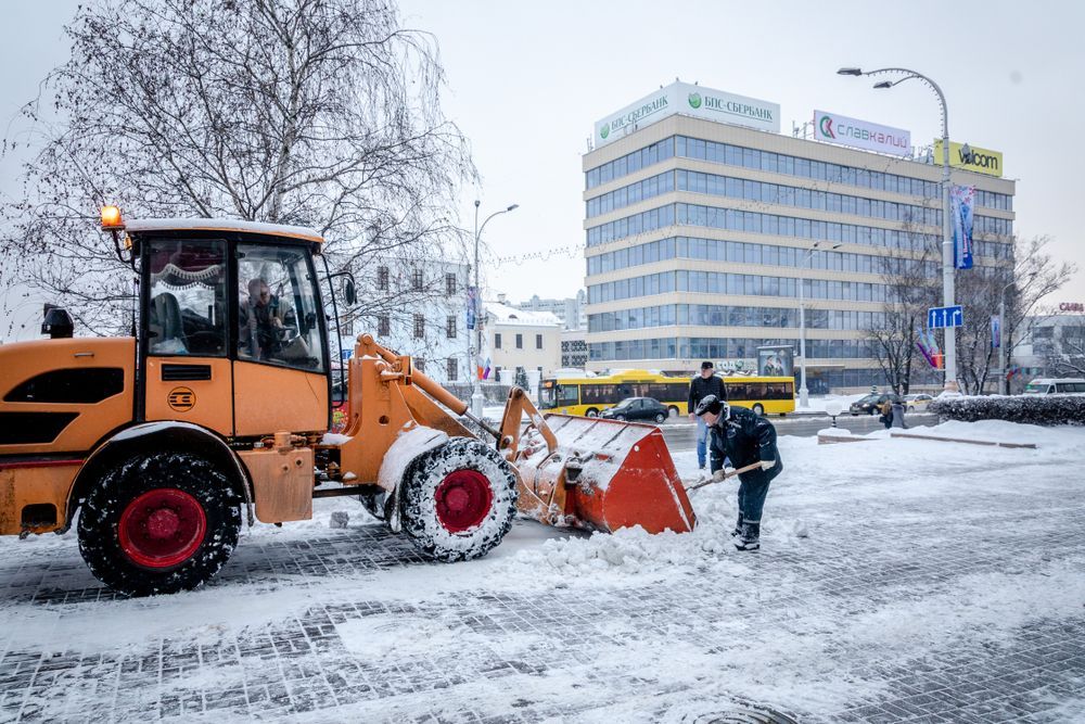 A snow plow is clearing snow from a city street.