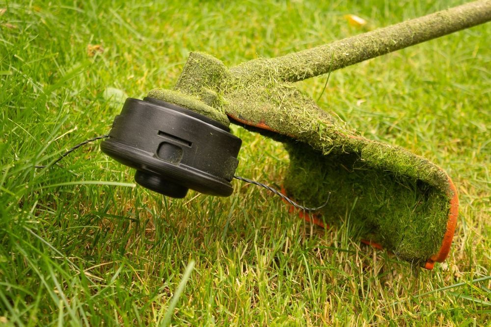 A close up of a lawn mower cutting grass on a lush green lawn.