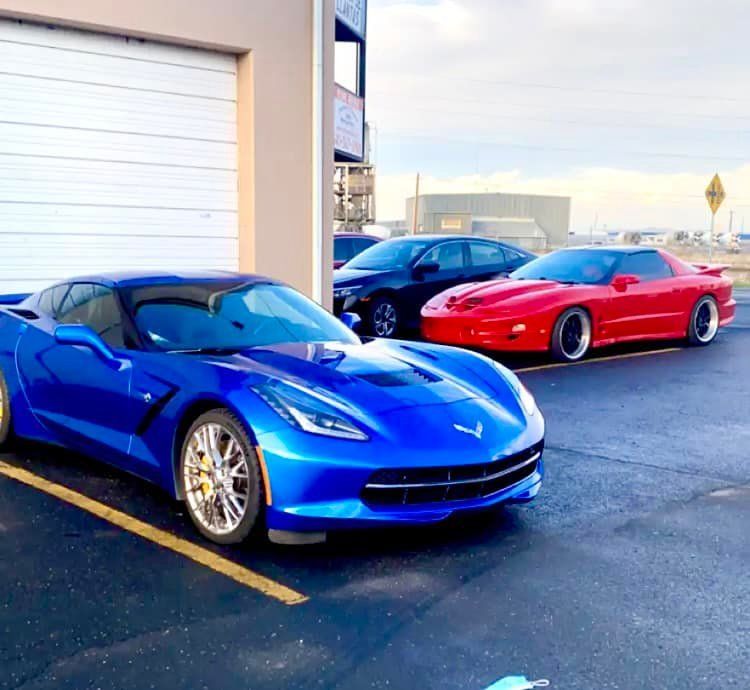 A blue sports car is parked next to a red sports car
