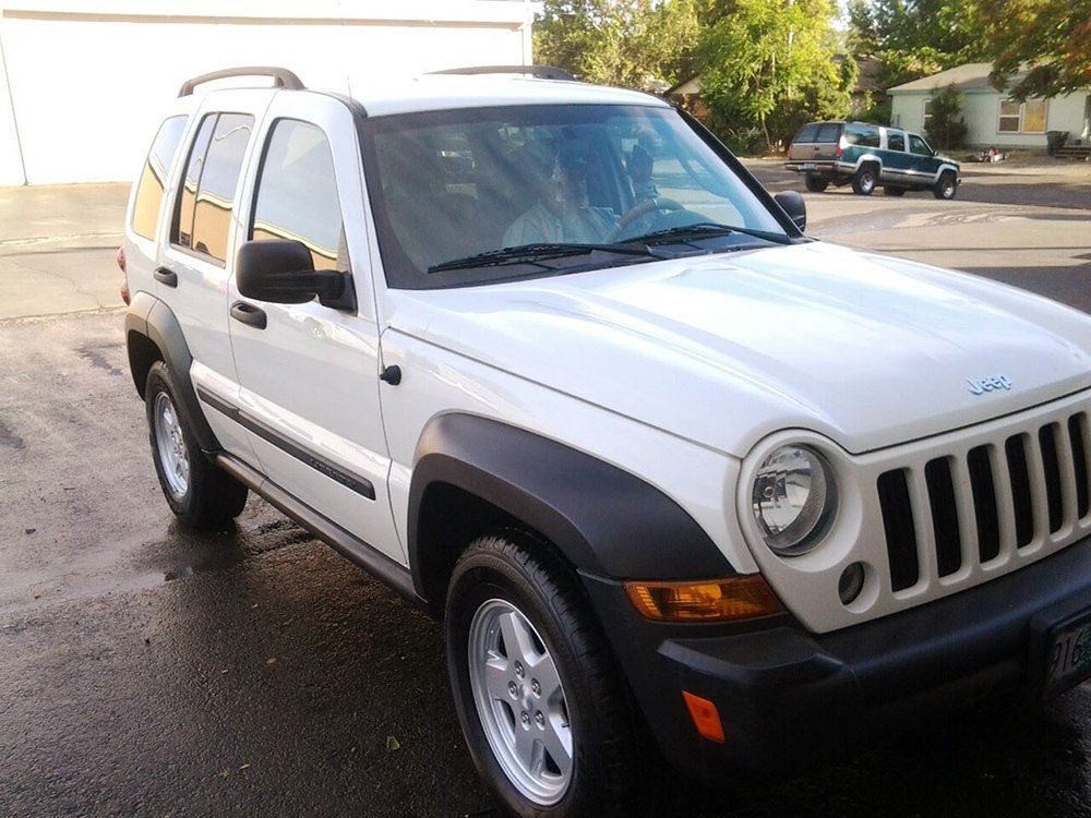 A white jeep is parked in a parking lot