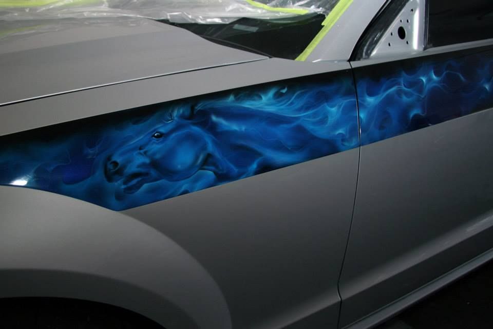 A car with a horse painted on the side of it