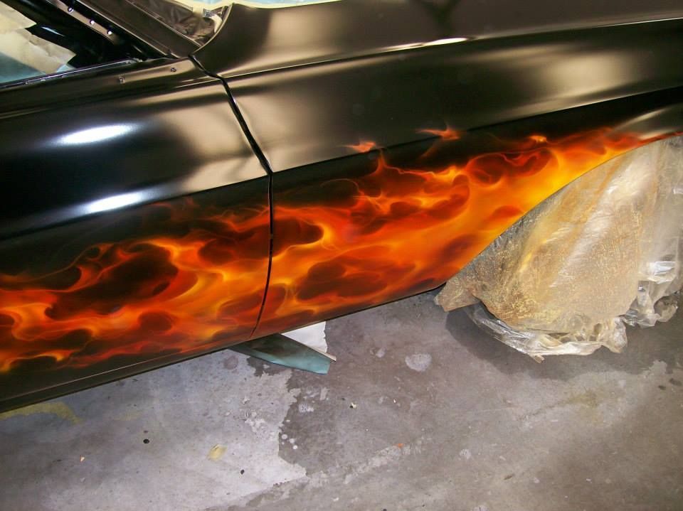 A black car with flames painted on the side