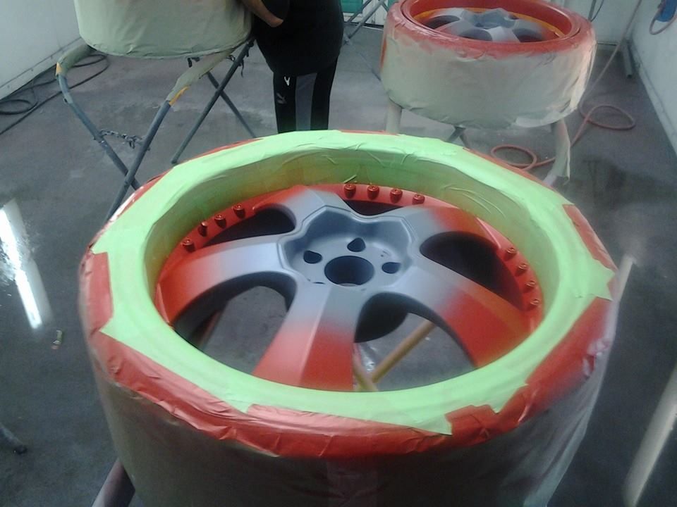 A car wheel is being painted red and green