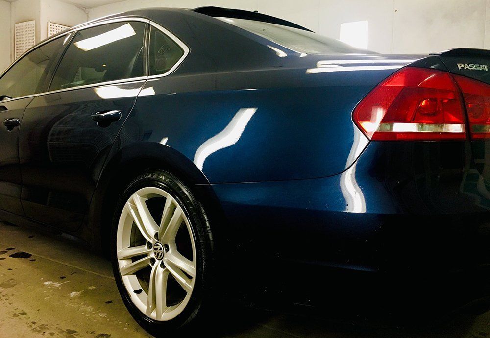 A blue volkswagen passat is parked in a garage.