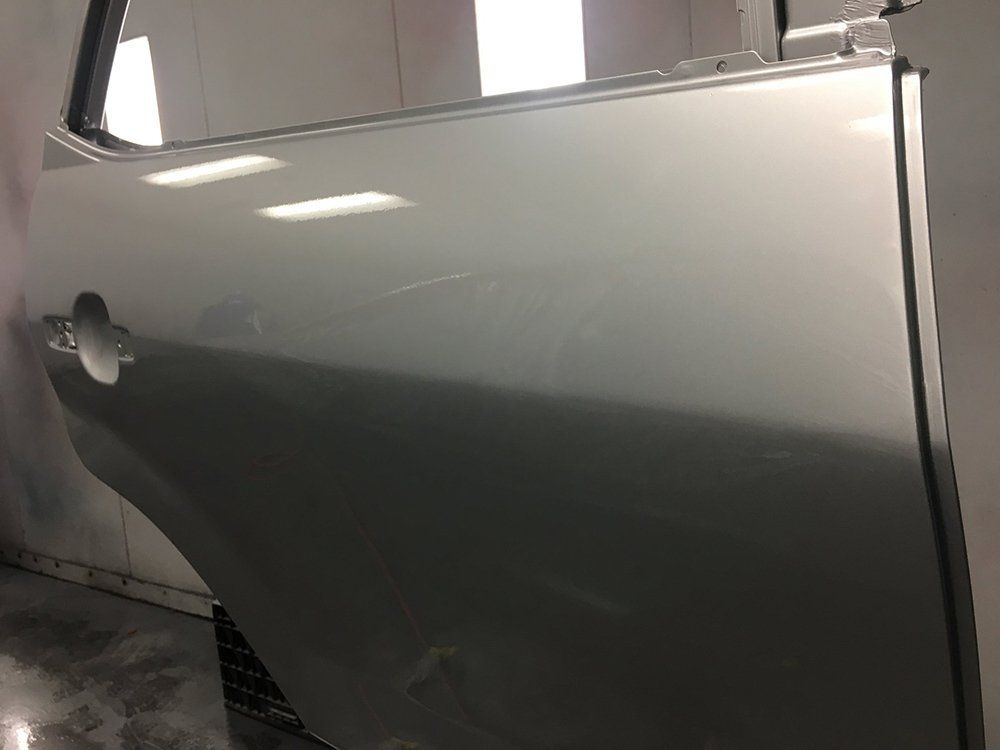 A silver car door is sitting on a table in a room.