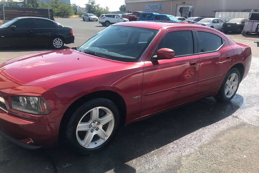 A red dodge charger is parked in a parking lot.