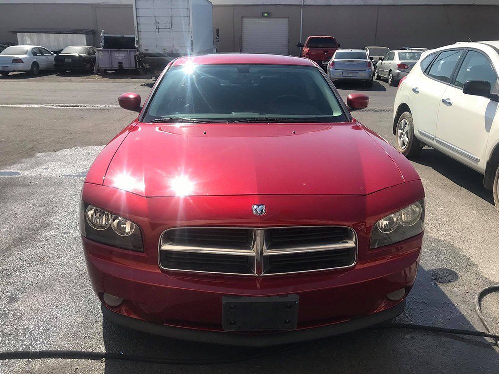 A red dodge charger is parked in a parking lot