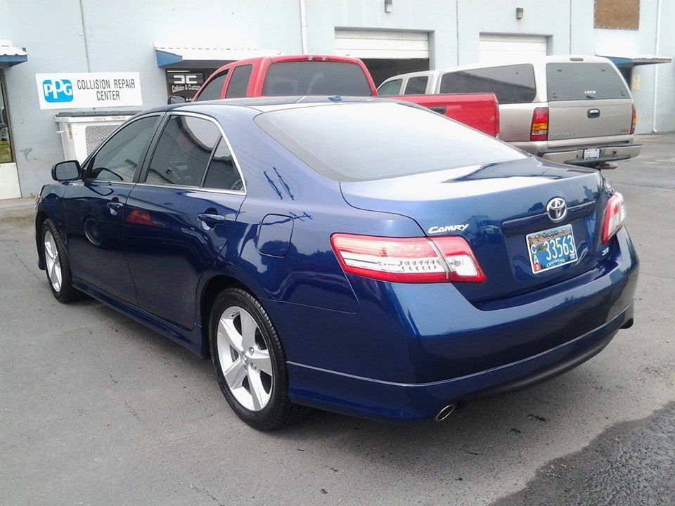 A blue toyota car is parked in front of a building