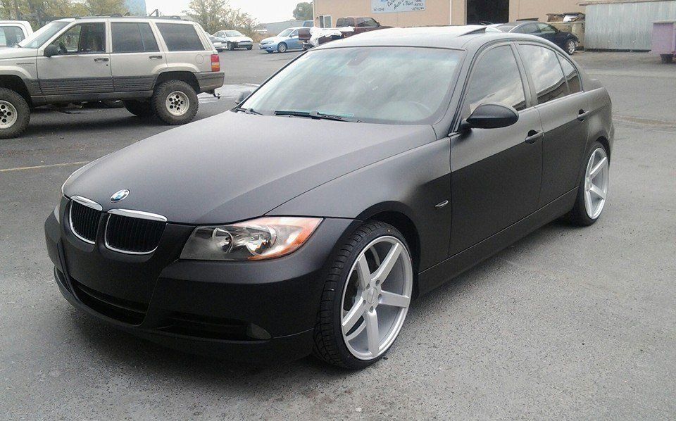 A black bmw is parked in a parking lot