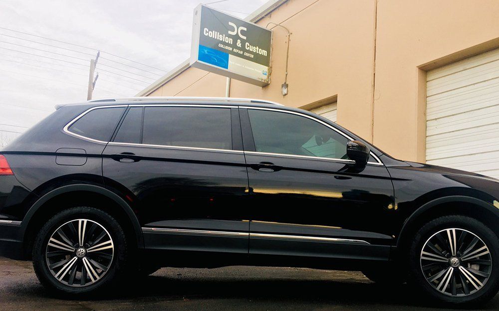 A black suv is parked in front of a building.