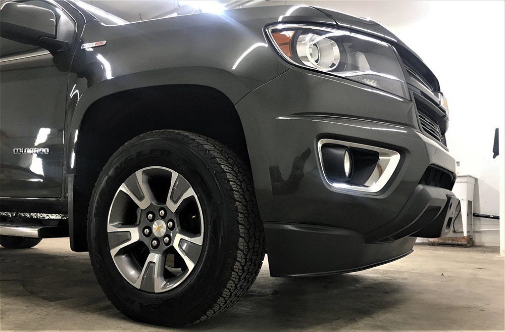 A gray truck is parked in a garage.