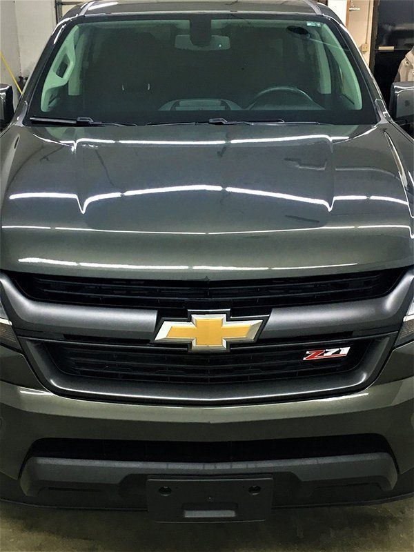 A gray chevrolet truck is parked in a garage