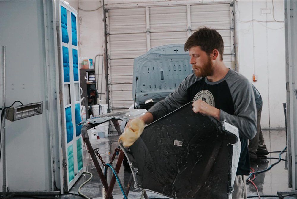 A man is working on a car in a garage.