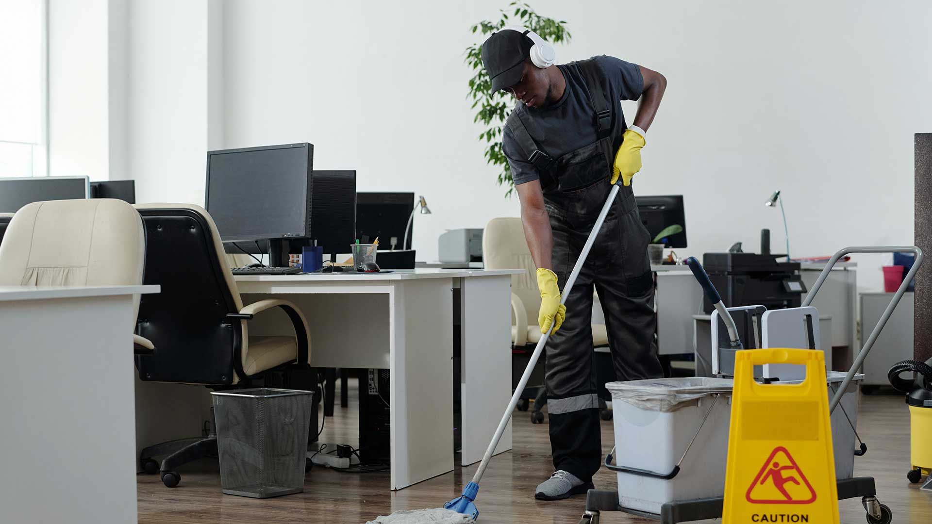 A man is vacuuming the floor and a woman is cleaning the windows.