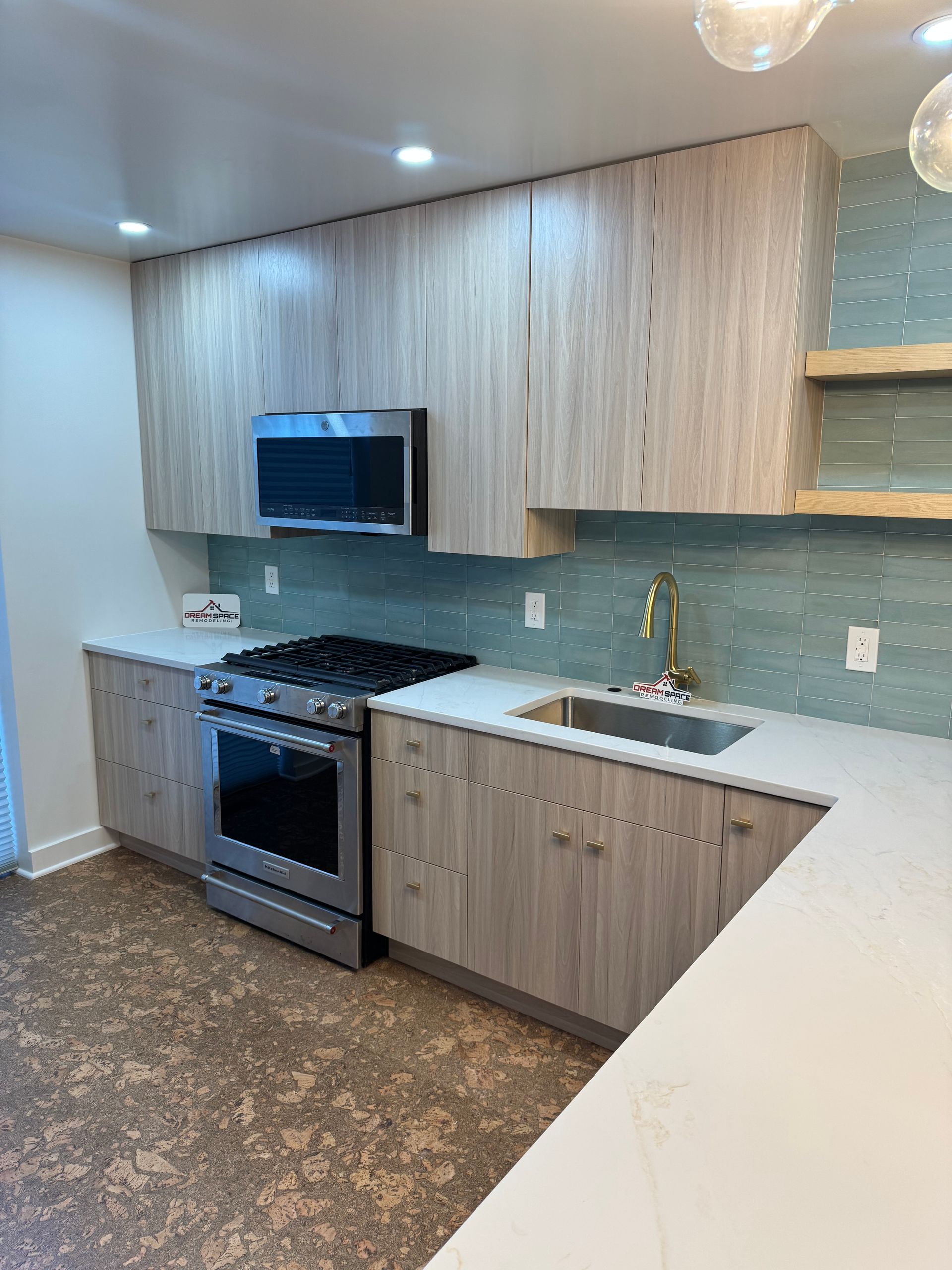 Contemporary slab cabinet kitchen with push-up openers — wide view with lighting.