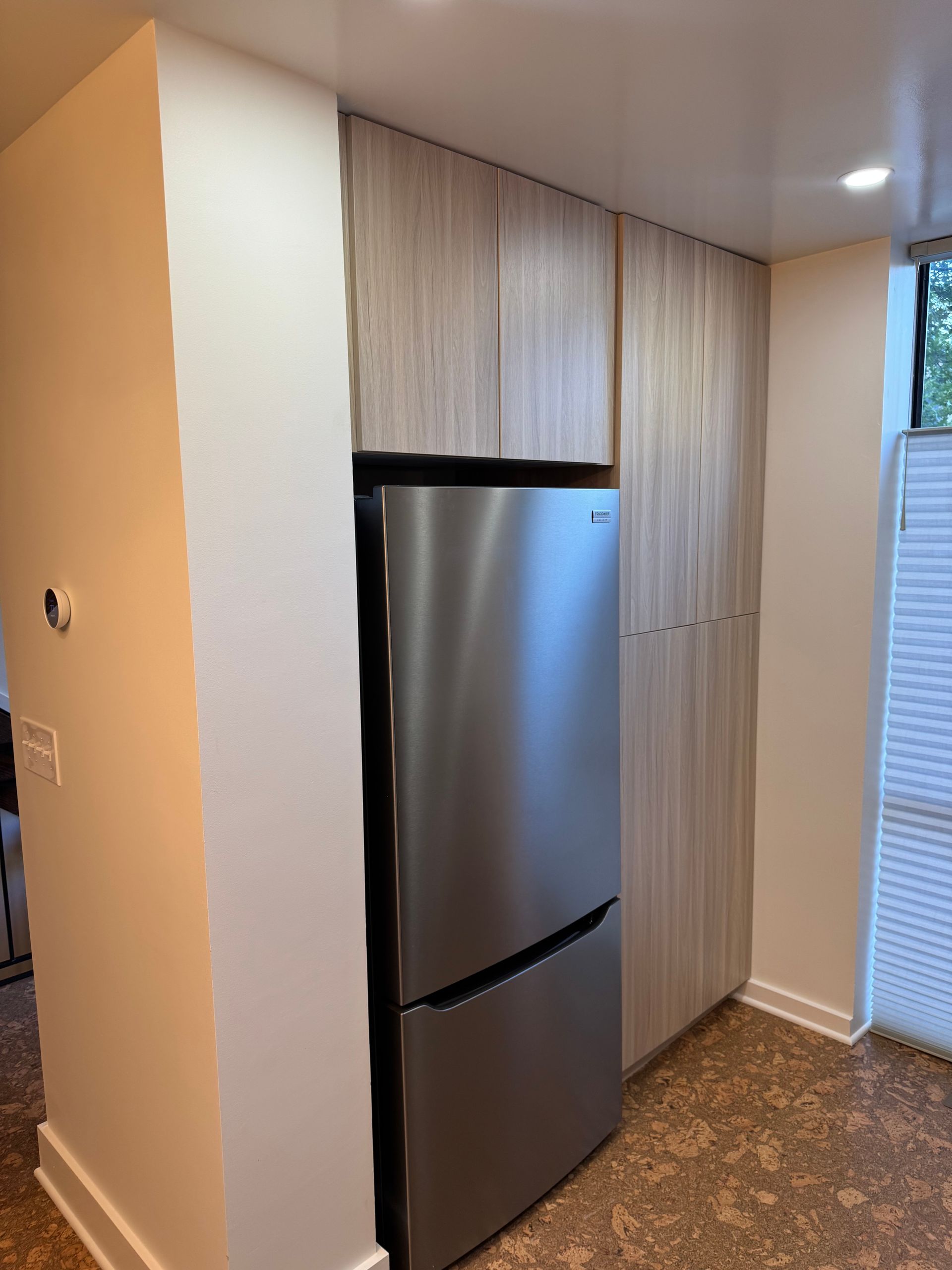 Minimalist kitchen remodel with slab door cabinets, quartz counters, and push-up openers — island view.