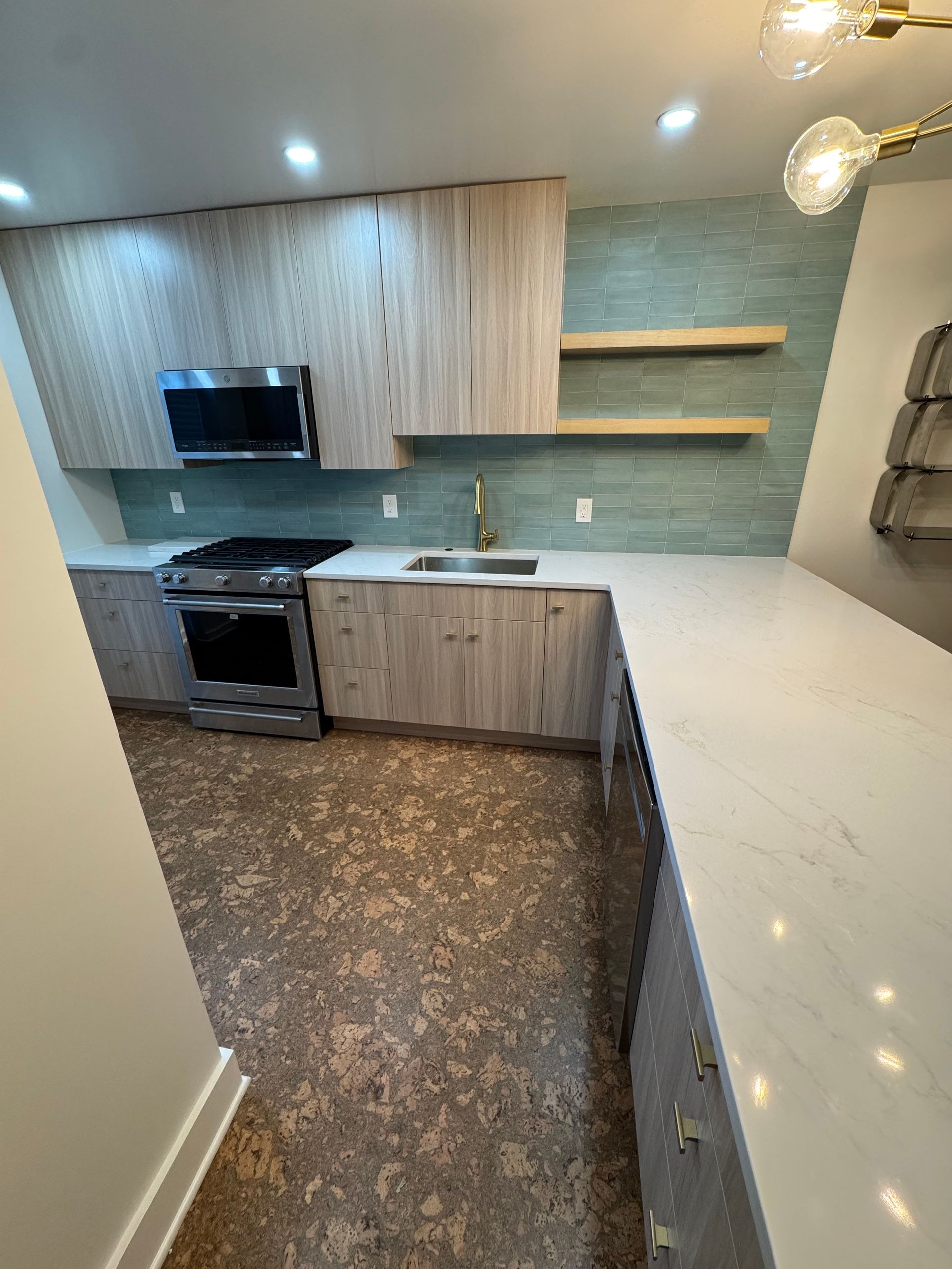 Modern remodeled kitchen with natural wood slab-style cabinets, minimalistic design, quartz countertops, and push-up door openers.